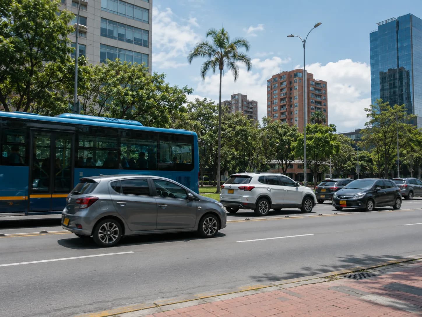 Vehículos de transporte público y particular en una vía urbana colombiana